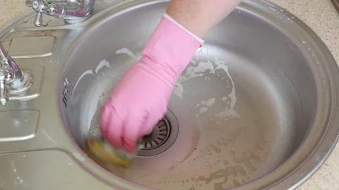 Hand in a rubber glove cleans the kitchen sink. Close-up Stock-Footage 111146306