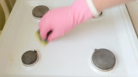 Hand in a rubber glove cleans the surface of the gas stove Vidéo 111145872