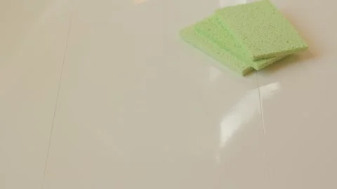 Hand in a rubber glove is putting a sponge and a brush on a tile surface. Stock Footage 132696174