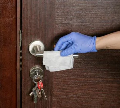 Hand in rubber protective glove with microfiber cloth cleaning door with stai Stock-Fotos