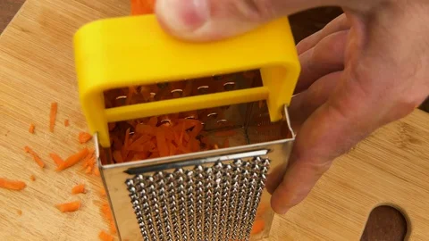 Hand rubbing carrot on grater. Reverse side of grater. Stock Footage 130105748