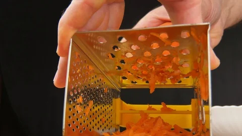 Hand rubbing carrot on grater. Reverse side of grater. 库存影片 130105768