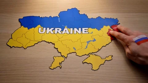 A hand with a Russian flag chips away at Donetsk and Lugansk. map of Ukraine Stock Footage 170909013
