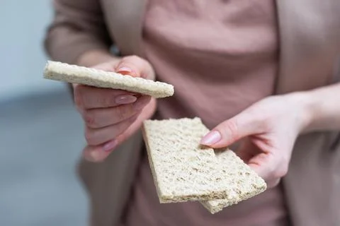 Hand with salty cracker, crispy appetizer, rectangle shape cookie. Isolated on Foto stock