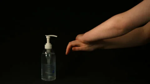 Hand sanitiser being used on black background Pt 4 of 4 Stock Footage 149696602