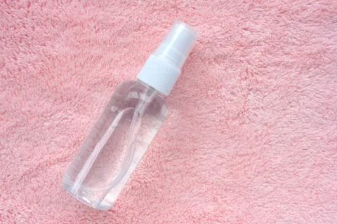 Hand sanitizer bottle on soft pink towel textured background. Stock Photos