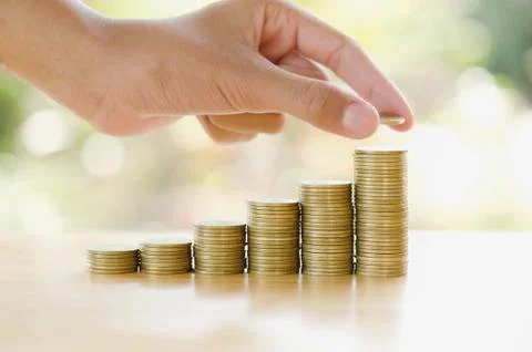 Hand save money with stack money coin for growing graph your business Stock Photos