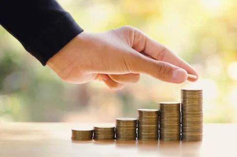 Hand save money with stack money coin for growing graph your business Stock Photos