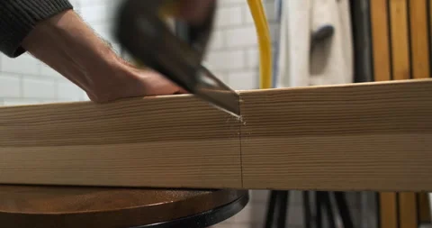 Hand saw saws thick square wooden beam, back view, close-up, indoors, wood Video stock 256145123