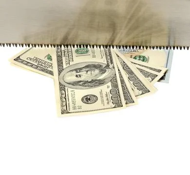 Hand sawing a bundle of US dollars. Metaphor. Free space for text. Stock Photos