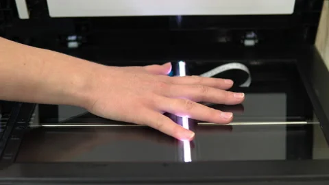 Hand scanning process. Scanner in operation scans a human hand with the lid open Stock Footage 146319125