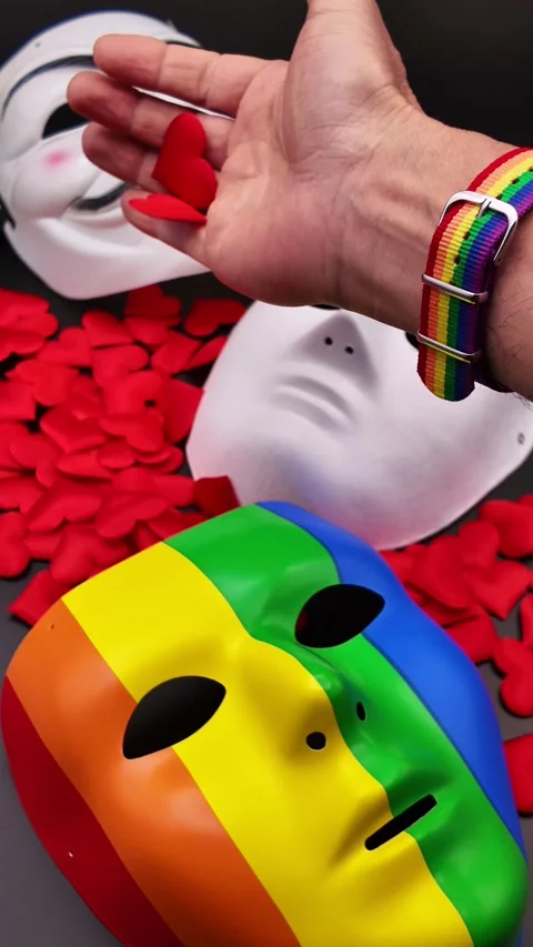 Hand scattering rose petals over pride masks Vídeos de archivo 329451735