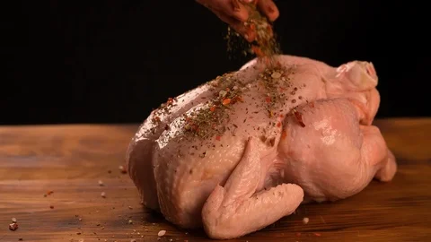 Hand scattering Spices on raw Chicken cooking food slow motion video Stock Footage 102618469