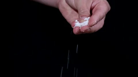 Hand scatters salt on a black background. Stock-Footage 131445669