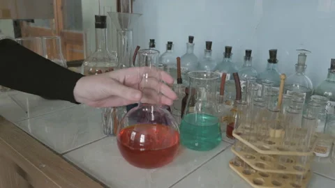 The hand of a scientist rearranges one flask to another place Stock Footage 86232859