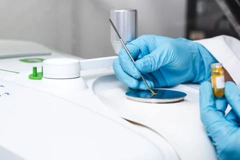 Hand of the scientist using a stainless spatula to scoop sample solid from .. Stock Photos
