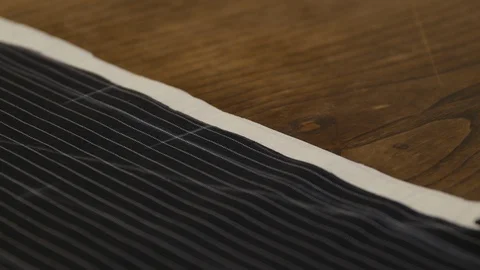 Hand with scissors black fabric. Close-up of cutting process. Sewing tutorial. Video stock 127251885