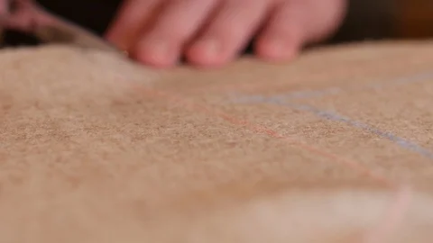 Hand with scissors cut beige natural tweed fabric. Close-up of cutting process. Stock Footage 128993374