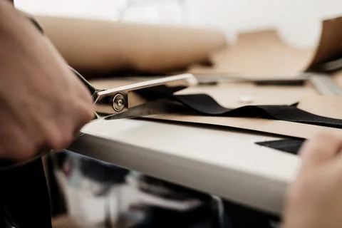 Hand with scissors cutting fabric Stock Photos