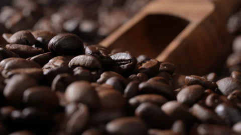 Hand scooping coffee beans using wooden spoon from a large pile of coffee beans. Видео 177524112