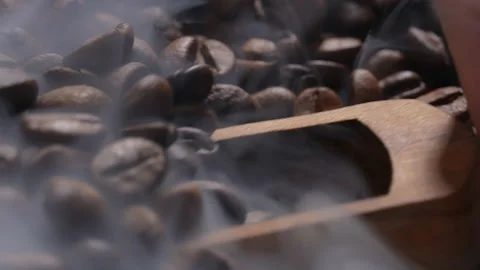 Hand scooping coffee beans using wooden spoon from a large pile of coffee beans. Stock Footage 177525411