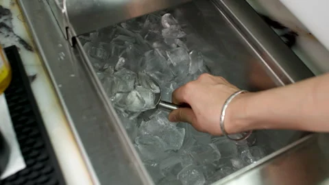 Hand Scooping Ice Cubes from Metal Bin in Commercial Kitchen or Bar Environment Stock Footage 337653100