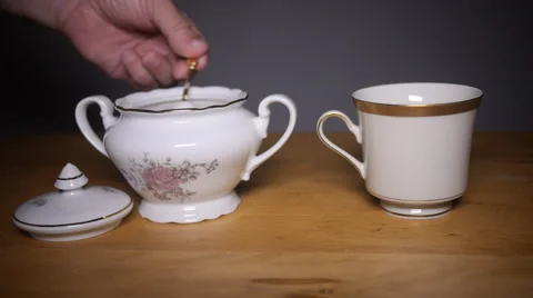 Hand scooping lots of sugar with spoon into cup of coffee Stock Footage 54809658