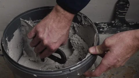 Hand scooping plaster from bucket Stock Footage 329356709