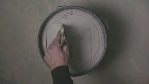 Hand scooping plaster from open bucket, Top down view Stock Footage 329356728