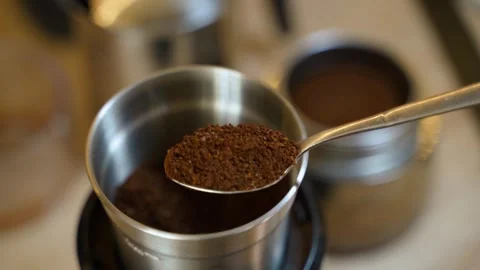 A hand scoops freshly ground coffee into a teaspoon, close-up on the background Stock Footage 283568415
