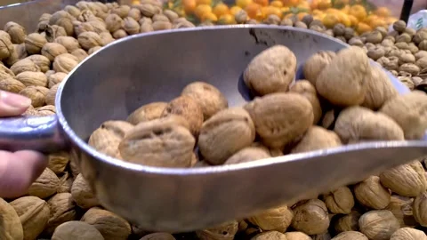 Hand scoops walnuts at grocery store Video stock 134432440