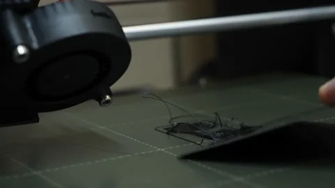 Hand scrapes off misprint with scraper, from 3D printer, close-up, fail 動画素材 156034024