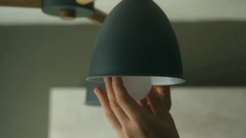 Hand screwing led lightbulb into ceiling lamp holder Stock-Footage 318610394