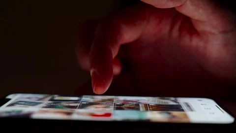 Hand scrolling on smartphone screen in dark environment Stock Footage 264981996