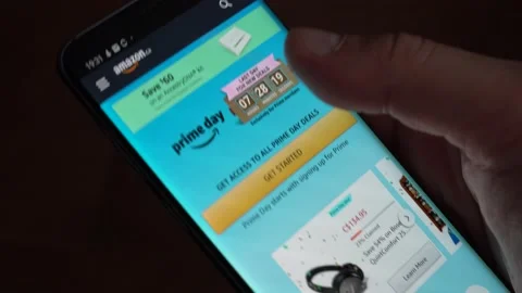 A hand scrolling through deals on Amazon Prime Day Video stock 131210416