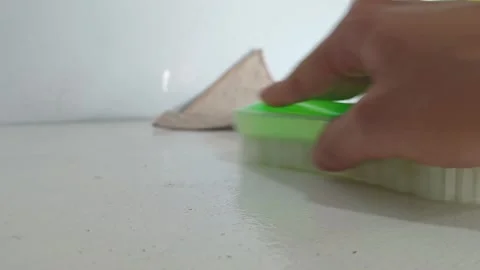 Hand Scrubbing White Surface with Green Cleaning Brush Stock Footage 346357202