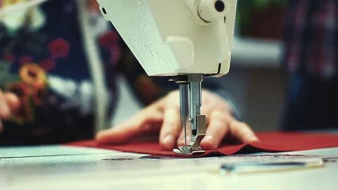 Hand seamstresses confidently scribbling red fabric on the sewing machine Stock Footage 104265972