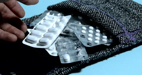 Hand searching in a medication holder in textile bag Stock Footage 197337752