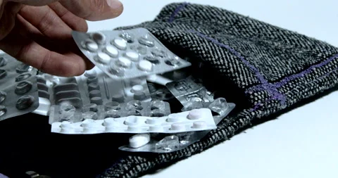 Hand searching in a medication holder in textile bag Stock Footage 197337901
