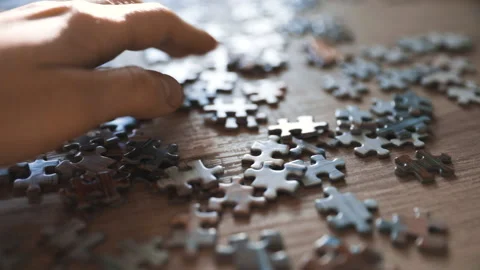 Hand searching for the missing piece in a puzzle - slow motion, pan shot Stock Footage 131922556