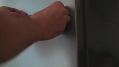 A hand is seen approaching a fridge door, ready to open it. A note labeled yummy Stock-Footage 339096358