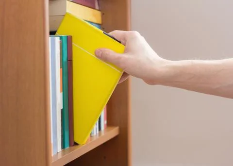 Hand selecting book Stock Photos