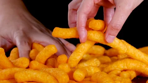 Hand Selecting Cheese Puffs from Pile on Black Background Stock Footage 319462604
