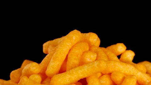Hand Selecting Cheese Puffs from Pile Against Black Background Stock Footage 319742520