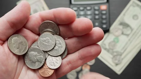 Hand Selecting Coins With Calculator and Money in Background Video stock 346730552