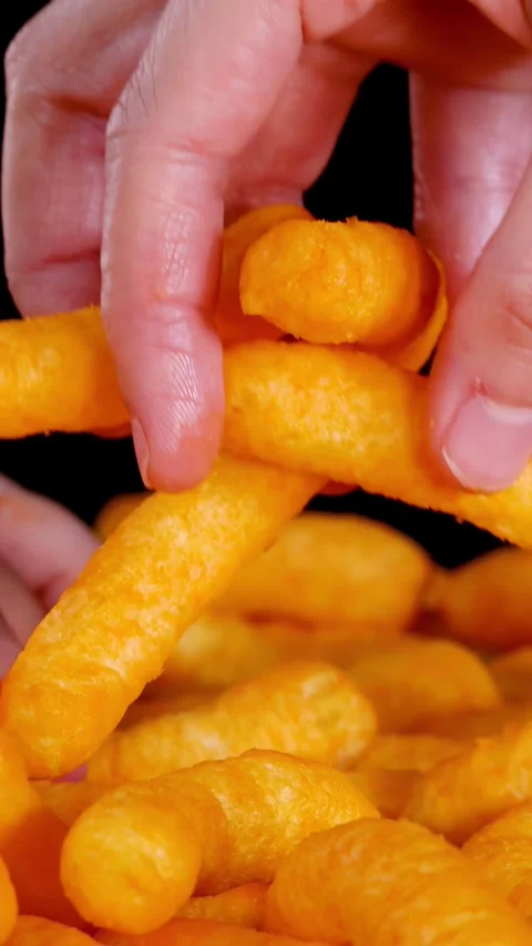 Hand Selecting Crispy Cheese Puffs Snack Against Black Background Stock Footage 320163693