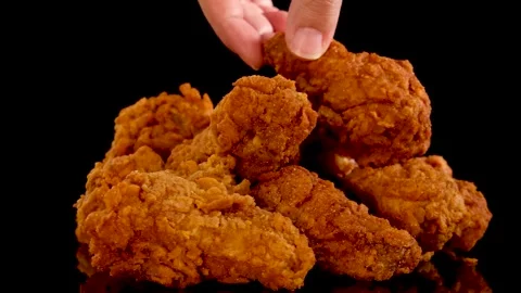 Hand Selecting Crispy Fried Chicken Pieces on Black Background Video stock 313095382