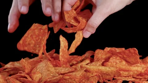 Hand Selecting Crispy Nacho Chips From Pile on Black Background Stock Footage 319813088