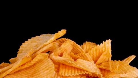 Hand Selecting Crispy Potato Chip From Pile on Black Background Stockbeeldmateriaal 319512759