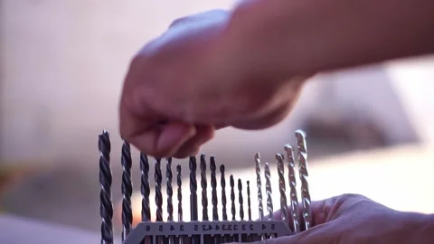 Hand selecting a drill bit from an organized set on a workbench. Tool footage Stock Footage 346221825